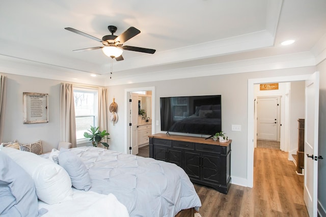 bedroom with ceiling fan, hardwood / wood-style floors, and a raised ceiling