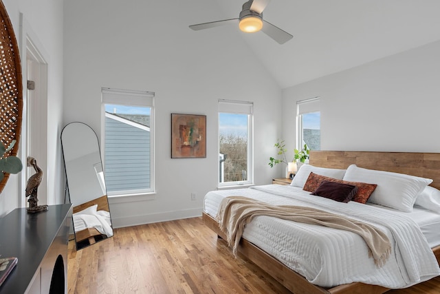 bedroom featuring ceiling fan, high vaulted ceiling, and light hardwood / wood-style flooring