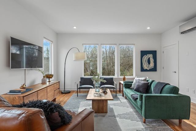 living room featuring light hardwood / wood-style flooring and an AC wall unit