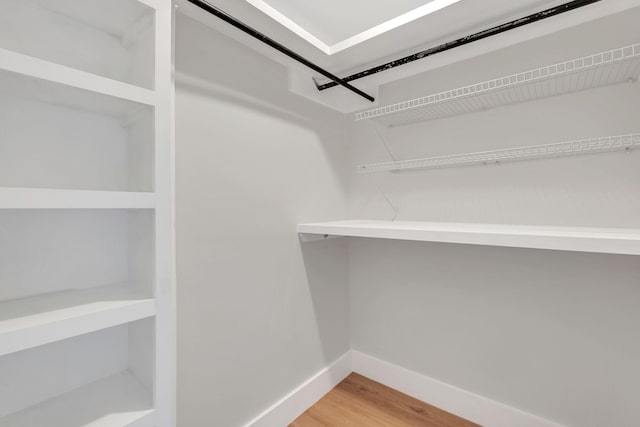 walk in closet with hardwood / wood-style flooring