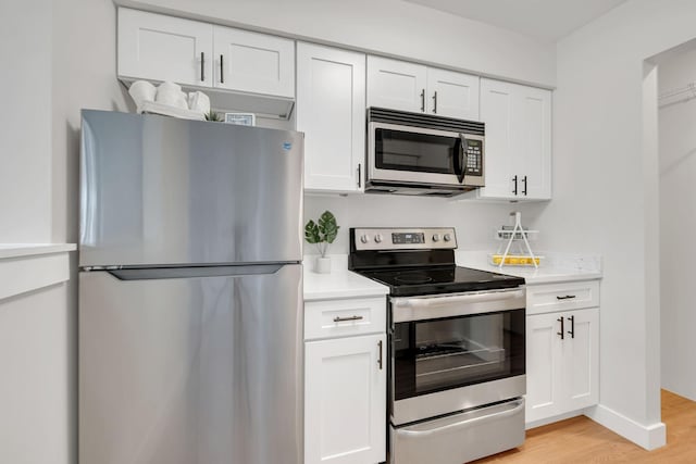 kitchen with white cabinetry, appliances with stainless steel finishes, and light wood-type flooring