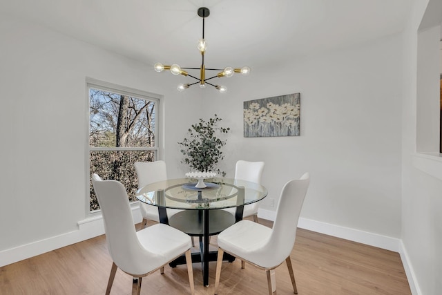 dining area featuring wood-type flooring and a notable chandelier