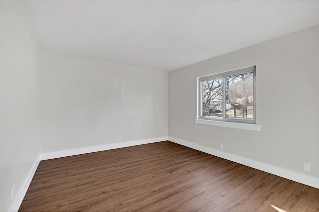 unfurnished room with dark hardwood / wood-style flooring