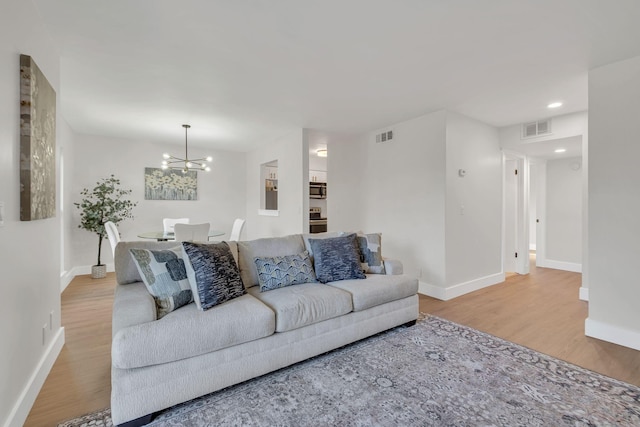 living room with a chandelier and light hardwood / wood-style floors