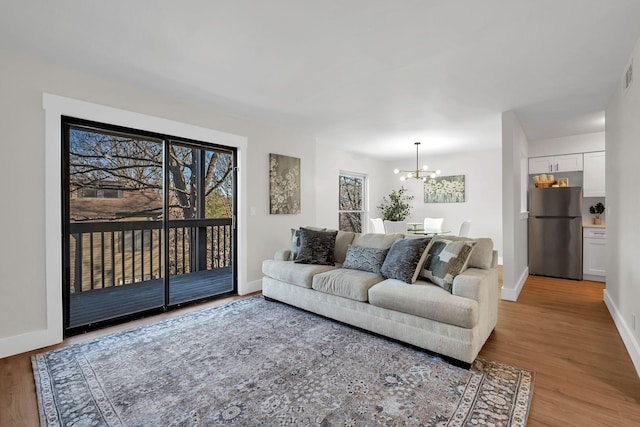 living room with a notable chandelier and light hardwood / wood-style floors