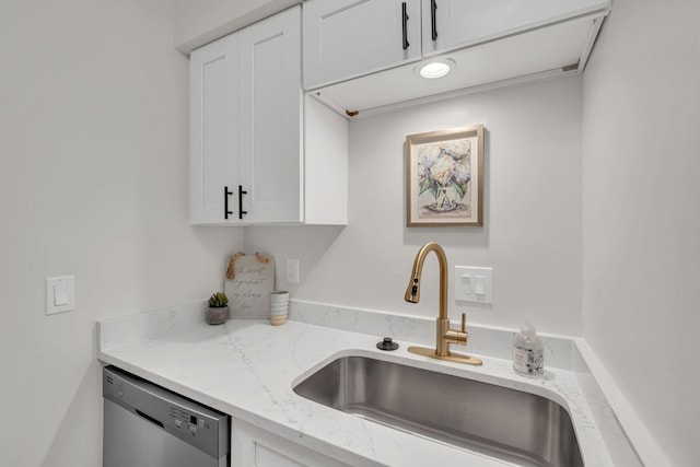 kitchen with light stone counters, sink, white cabinets, and stainless steel dishwasher