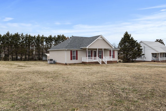 view of front of property with covered porch, cooling unit, and a front lawn