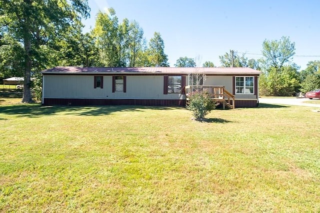 rear view of property with a wooden deck and a yard