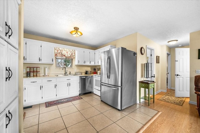 kitchen featuring sink, white cabinets, appliances with stainless steel finishes, and a textured ceiling