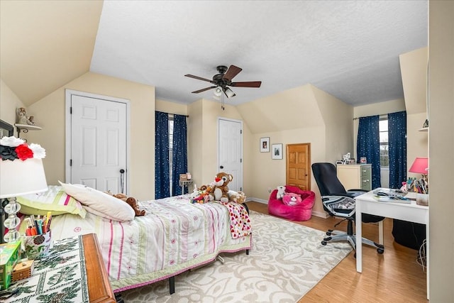 bedroom featuring hardwood / wood-style flooring, vaulted ceiling, and ceiling fan