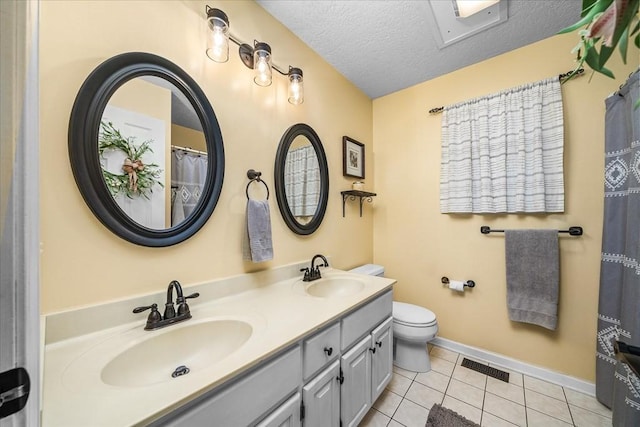 bathroom featuring toilet, a textured ceiling, tile patterned floors, and vanity