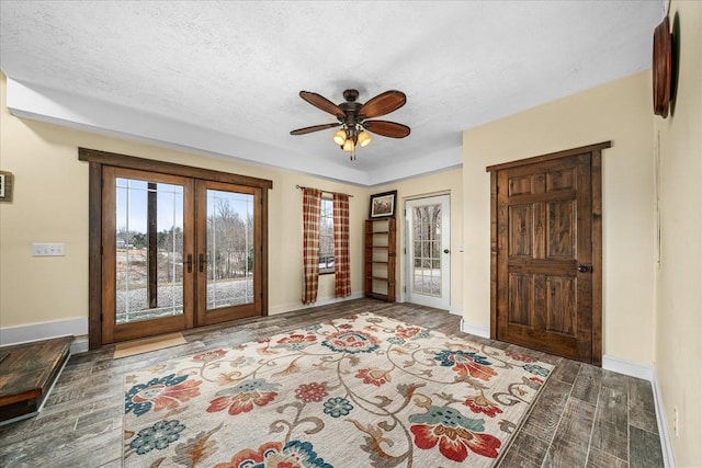 entryway with a textured ceiling, ceiling fan, and french doors