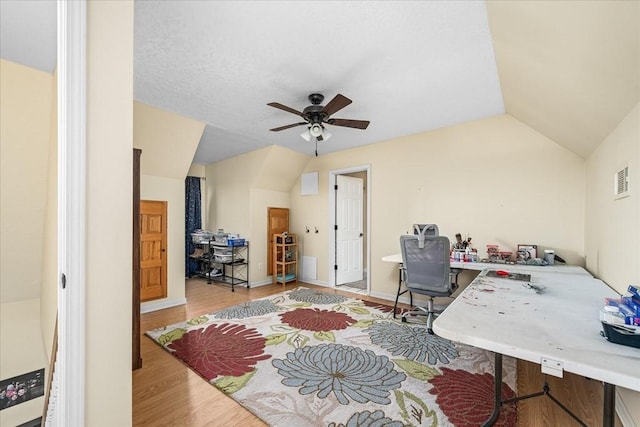 home office with vaulted ceiling, ceiling fan, and wood-type flooring