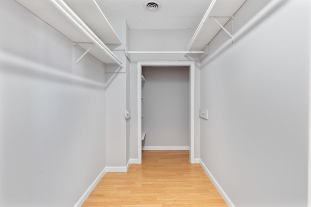 spacious closet with hardwood / wood-style floors