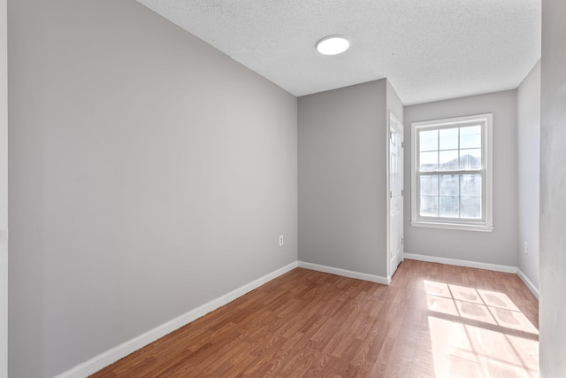 empty room with hardwood / wood-style flooring and a textured ceiling