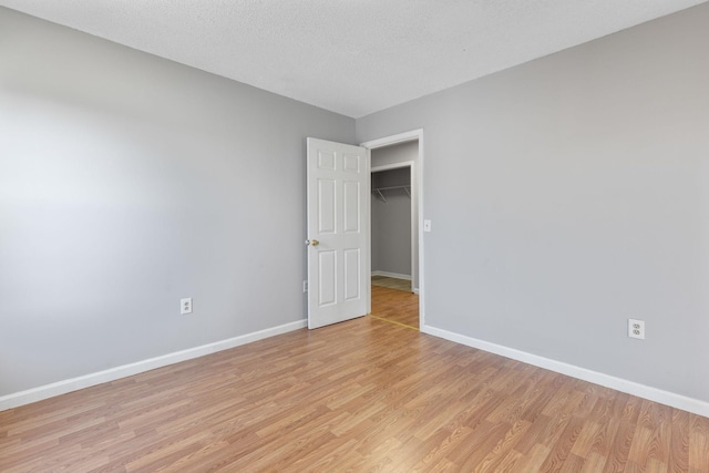 spare room with light hardwood / wood-style flooring and a textured ceiling