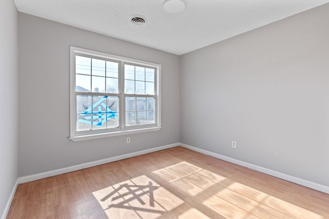 unfurnished room featuring wood-type flooring and a textured ceiling