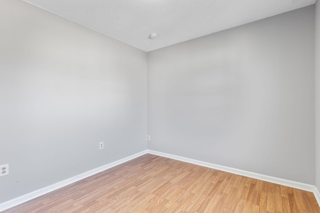 empty room with light hardwood / wood-style flooring and a textured ceiling