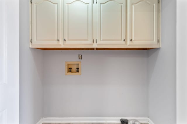 clothes washing area with cabinets and washer hookup