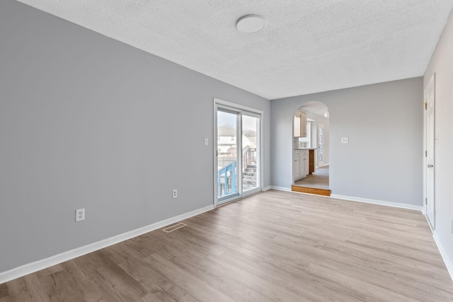 unfurnished room with light hardwood / wood-style floors and a textured ceiling