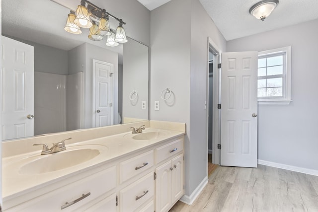 bathroom featuring vanity, hardwood / wood-style floors, and a textured ceiling