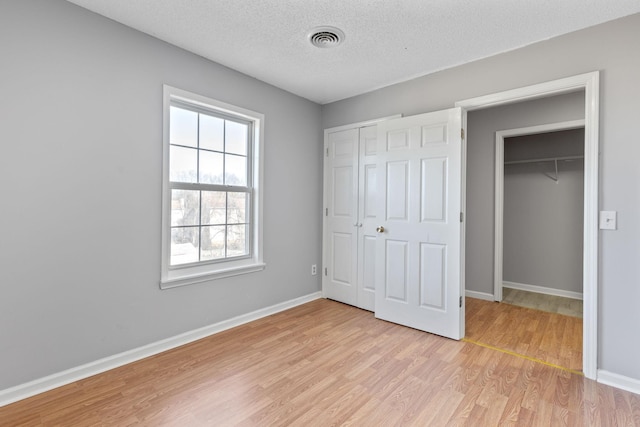 unfurnished bedroom featuring light hardwood / wood-style floors and a textured ceiling