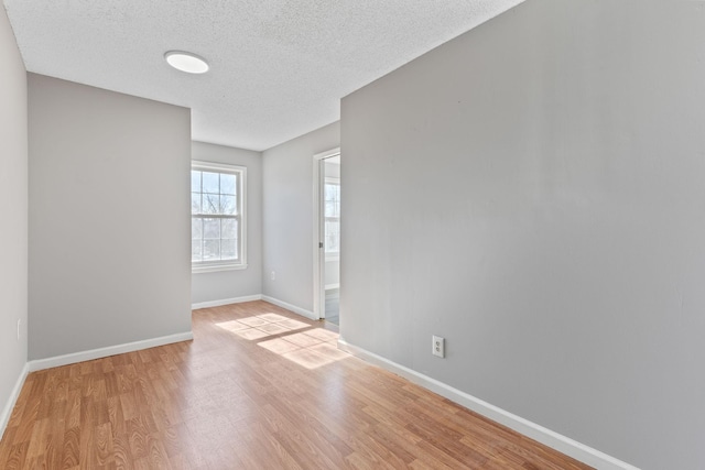 spare room with light hardwood / wood-style floors and a textured ceiling