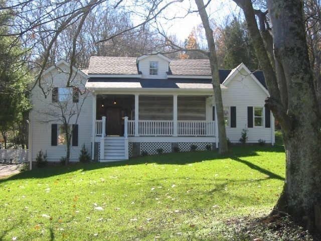 view of front of home with covered porch and a front yard