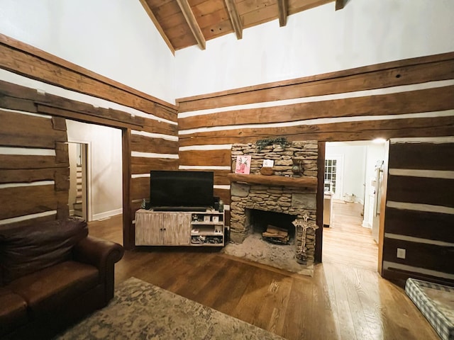 living room featuring hardwood / wood-style floors, high vaulted ceiling, a fireplace, wooden ceiling, and beam ceiling