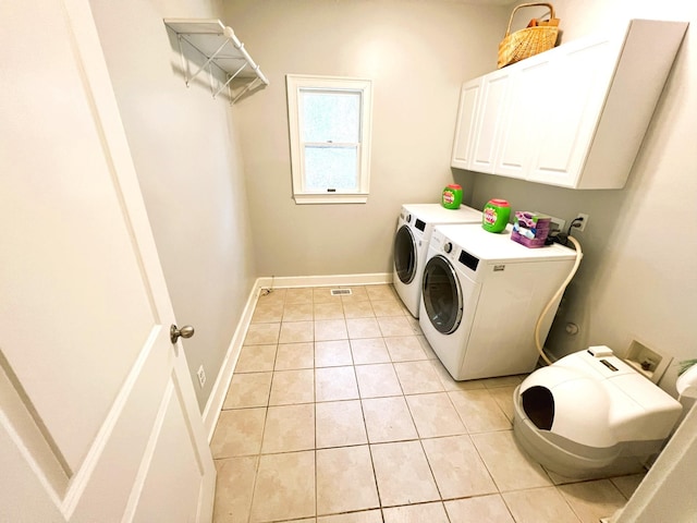 washroom with cabinets, washer and dryer, and light tile patterned floors