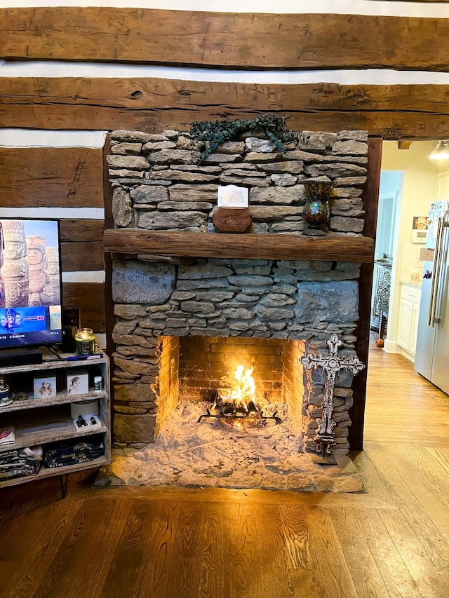 interior details with stainless steel refrigerator, a fireplace, and hardwood / wood-style floors