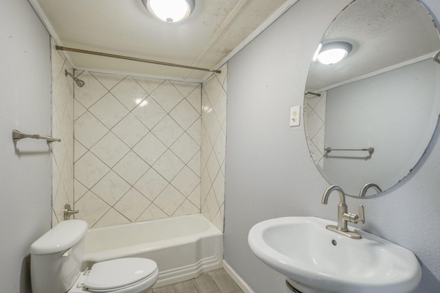 full bathroom featuring sink, toilet, tiled shower / bath, and crown molding