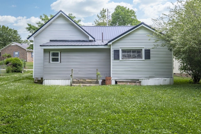 back of property featuring a yard