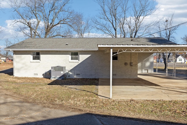 rear view of house with cooling unit and a carport