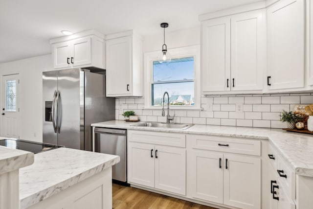 kitchen with sink, white cabinetry, appliances with stainless steel finishes, and light hardwood / wood-style flooring