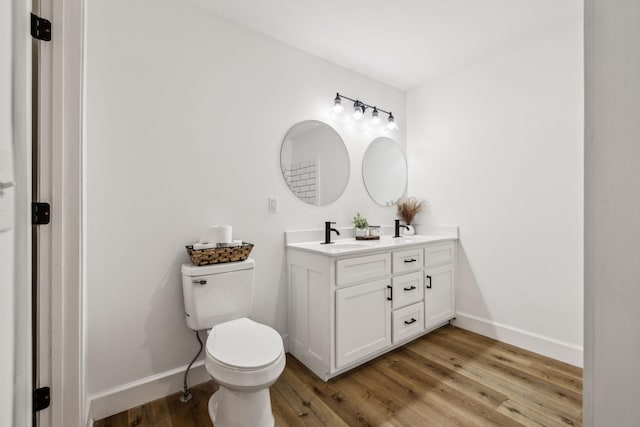 bathroom with hardwood / wood-style floors, toilet, and vanity