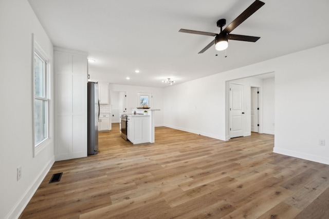 unfurnished living room with light wood-type flooring and ceiling fan