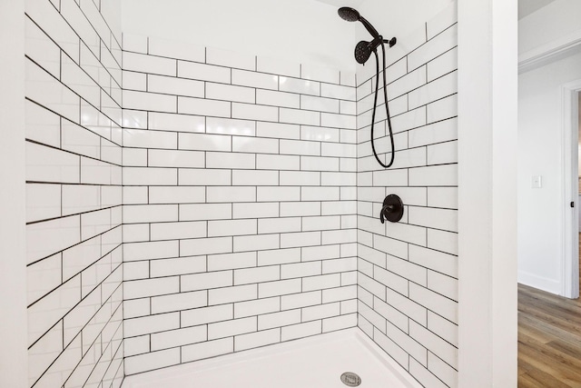 bathroom featuring hardwood / wood-style flooring and tiled shower