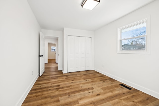 unfurnished bedroom with wood-type flooring and a closet