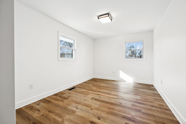 empty room featuring hardwood / wood-style floors and plenty of natural light