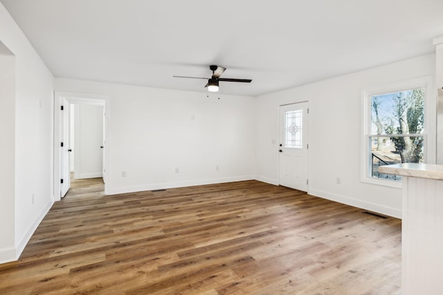 empty room with hardwood / wood-style flooring and ceiling fan