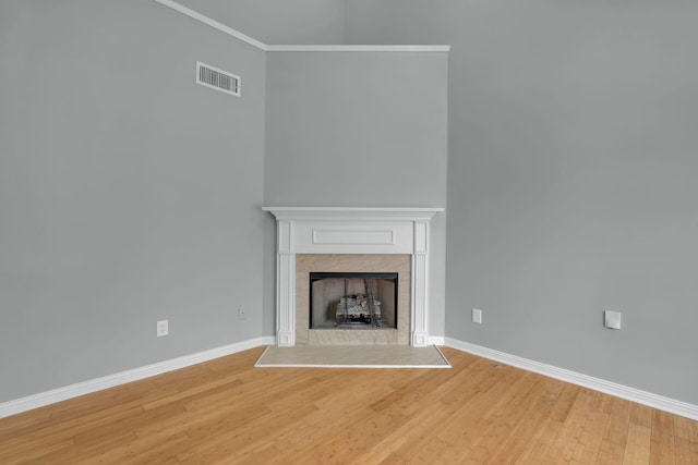 unfurnished living room with crown molding and wood-type flooring