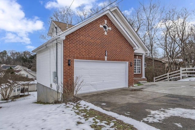 view of snowy exterior featuring a garage