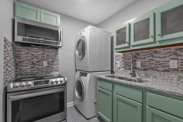 washroom with sink and stacked washer / dryer