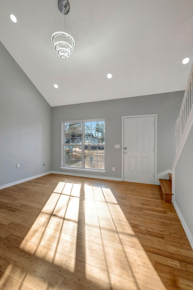 interior space featuring lofted ceiling, a notable chandelier, and light wood-type flooring