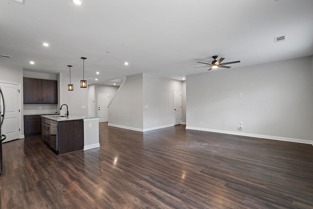 kitchen with dishwasher, hanging light fixtures, a kitchen island with sink, dark brown cabinetry, and dark hardwood / wood-style floors