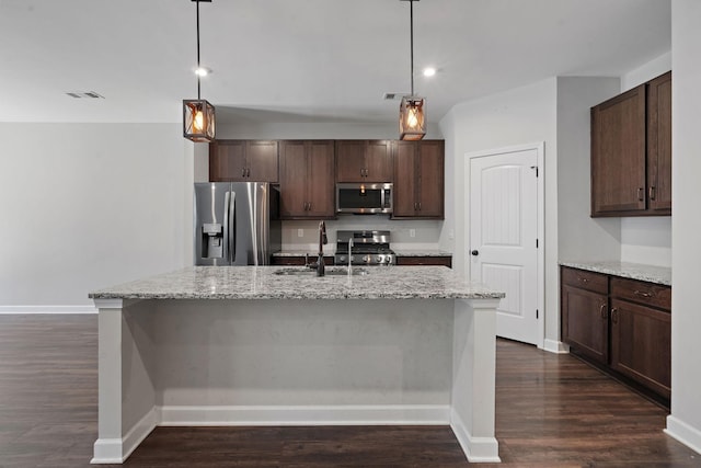 kitchen featuring decorative light fixtures, light stone countertops, and stainless steel appliances