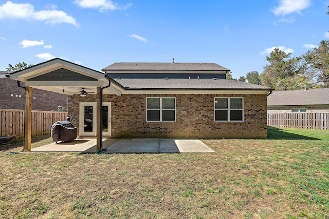 rear view of property with ceiling fan, a patio, and a yard