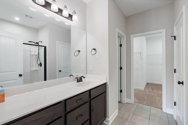 bathroom with tile patterned floors, a shower with door, and vanity