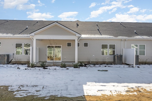 snow covered property with central AC unit